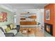 Bright living room featuring hardwood floors, a fireplace, and stylish built-in shelving at 1338 S Fairfax St, Denver, CO 80222