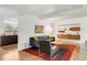 Open-concept living room with hardwood floors, stylish furnishings, and seamless flow to the kitchen at 1338 S Fairfax St, Denver, CO 80222