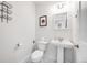 A stylish white powder room with a pedestal sink, marble floors, and modern fixtures at 2922 W 26Th Ave # 1, Denver, CO 80211