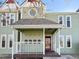 Charming light-green home featuring a covered front porch with white railings and a red front door at 1203 6Th St # 1203, Golden, CO 80403
