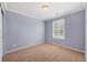 Bedroom featuring a light purple wall, neutral carpet, and a window with plantation shutters at 22898 Addington Pl, Parker, CO 80138
