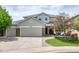 Charming two-story home featuring a three car garage, landscaped yard, and stone accents at 22898 Addington Pl, Parker, CO 80138
