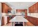 Spacious kitchen featuring custom wood cabinets, a large island with seating, and stainless steel appliances at 22898 Addington Pl, Parker, CO 80138