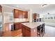 Modern kitchen featuring an island with seating, hardwood floors, and stainless steel appliances at 22898 Addington Pl, Parker, CO 80138