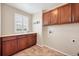 Well-lit laundry room features built-in cabinets and a sink with tile flooring at 22898 Addington Pl, Parker, CO 80138