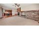 Open-concept living room with a stone fireplace, carpet, and hardwood floors leading to the kitchen at 22898 Addington Pl, Parker, CO 80138