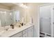 Bright bathroom featuring double sinks, generous countertop space, and a glass-enclosed shower at 1954 S Poplar Ct, Denver, CO 80224