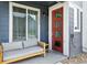 Inviting front porch featuring a modern red door, comfortable seating, and stylish accents at 1954 S Poplar Ct, Denver, CO 80224
