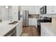 Well-equipped kitchen featuring stainless steel appliances, white cabinetry, and hardwood flooring at 1954 S Poplar Ct, Denver, CO 80224