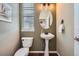 Charming powder room featuring a pedestal sink, decorative mirror, and stylish fixtures at 22991 Hope Dale Ave, Parker, CO 80138