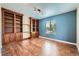 Bright office with built-in shelving, hardwood floors, and natural light from the window at 22991 Hope Dale Ave, Parker, CO 80138