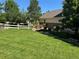 Spacious side yard boasts a manicured lawn and a classic wooden fence with lush green trees at 22991 Hope Dale Ave, Parker, CO 80138