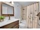 Well-maintained bathroom features a vanity, toilet, and shower with a floral shower curtain at 5183 Durham Ct, Denver, CO 80239