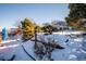 Snowy backyard landscape with retaining wall and trees at 11143 W Ohio Pl, Lakewood, CO 80226