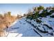 Sloped backyard with snow-covered landscaping at 11143 W Ohio Pl, Lakewood, CO 80226