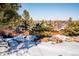 Landscaped backyard with snowy ground and a wooden fence at 11143 W Ohio Pl, Lakewood, CO 80226