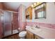 Bathroom with pink tile, shower/tub combo and wood vanity at 11143 W Ohio Pl, Lakewood, CO 80226