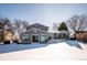 Back exterior view of the house with deck and snowy yard at 11143 W Ohio Pl, Lakewood, CO 80226