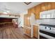 Kitchen with wood cabinets, white appliances, and hardwood floors at 11143 W Ohio Pl, Lakewood, CO 80226