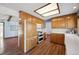 Kitchen with wood cabinets, white appliances, and hardwood floors at 11143 W Ohio Pl, Lakewood, CO 80226