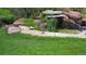 Landscaped backyard with pond, waterfall, and lush greenery at 11143 W Ohio Pl, Lakewood, CO 80226