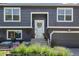 Close up of a gray home featuring an attached garage, and manicured flower beds at 3965 S Fundy Cir, Aurora, CO 80013