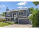 Two-story gray home featuring an attached garage, lush front lawn and manicured flower beds at 3965 S Fundy Cir, Aurora, CO 80013