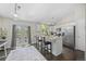 Bright kitchen with white cabinets, a breakfast bar, stainless steel appliances, and dark wood floors at 3965 S Fundy Cir, Aurora, CO 80013