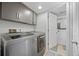 Laundry room features modern washer and dryer units with adjacent storage cabinets at 3965 S Fundy Cir, Aurora, CO 80013