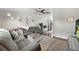 Open-concept living room with a gray sectional sofa, decorative wall art, and hardwood floors at 3965 S Fundy Cir, Aurora, CO 80013