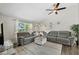 Spacious living room featuring a large gray sectional sofa, ceiling fan, and modern decor at 3965 S Fundy Cir, Aurora, CO 80013