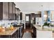 Modern kitchen with dark cabinets, granite countertops, and a large island at 9473 Kendrick Way, Arvada, CO 80007