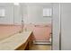 Retro bathroom with pink tile, updated countertops, and a well-maintained vintage aesthetic at 5960 Glencoe St, Commerce City, CO 80022