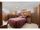 Cozy bedroom featuring wood paneling, traditional decor, and vintage furniture at 5960 Glencoe St, Commerce City, CO 80022
