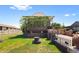 View of the brick home with a landscaped yard, gated driveway, and mature greenery at 5960 Glencoe St, Commerce City, CO 80022