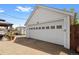 Spacious garage with a large door and ample parking and work area, offering additional storage options at 5960 Glencoe St, Commerce City, CO 80022