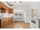 Bright kitchen featuring white appliances, wooden cabinets, and lots of natural light at 5960 Glencoe St, Commerce City, CO 80022