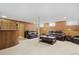 Inviting basement living room with a bar, comfortable seating area, and classic wood paneling at 5960 Glencoe St, Commerce City, CO 80022