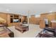 Spacious basement living room with a cozy seating area, classic wood paneling and a convenient bar area at 5960 Glencoe St, Commerce City, CO 80022