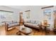 Inviting living room with hardwood floors, a cozy seating arrangement, and natural light at 5960 Glencoe St, Commerce City, CO 80022