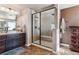 Bathroom with a walk-in shower, double vanity, and a large mirror at 8939 Devinney Ct, Arvada, CO 80005