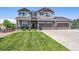 Two-story house with a large front yard, driveway, and attached two-car garage at 8939 Devinney Ct, Arvada, CO 80005