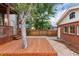 Backyard featuring a wooden deck with steps down to a gravel area next to a brick garage at 1352 N Downing St, Denver, CO 80218