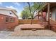 Landscaped backyard featuring a wooden deck, gravel area, and access to the brick garage at 1352 N Downing St, Denver, CO 80218