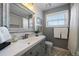 Modern bathroom with white subway tiles, gray vanity, and patterned floor at 5450 Flower Ct, Arvada, CO 80002