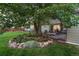 Relaxing patio area nestled beside a large tree and garden at 5450 Flower Ct, Arvada, CO 80002