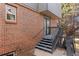 Back exterior view showcasing a small stoop and gray stairs leading to the backyard at 2609 S Quebec St # 9, Denver, CO 80231