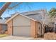 Two-car garage with brick and siding exterior, complemented by a well-maintained driveway at 2609 S Quebec St # 9, Denver, CO 80231