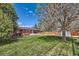 Serene backyard with lush green lawn, mature trees, and a covered patio with ample space to enjoy at 2986 W Union Ave, Englewood, CO 80110