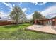 Large backyard featuring a lush lawn, mature trees, and a covered patio perfect for outdoor living at 2986 W Union Ave, Englewood, CO 80110